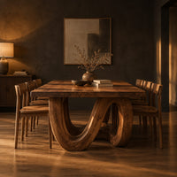 Dining table with a live edge top and a looping wave base in a dark dining room at golden hour