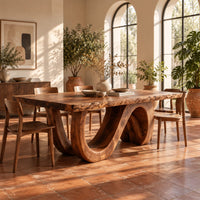 Dining table with a live edge top and a looping wave base in a bright dining room with arched windows and plants