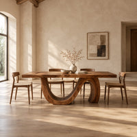 Dining table with a live edge top and a looping wave base in a bright open plan dining room