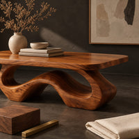 Corner detail of rectangle coffee table with softly shaped corners on a flowing wave loop base beside wood, brass and linen samples