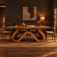 Long dining table on a single sculpted wave ribbon base in a dark dining room at golden hour