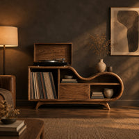 Low wooden record player stand with a wavy top and open record bay in a dark living room at golden hour