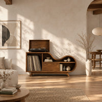 Low wooden record player stand with a wavy top and open record bay in a bright open plan living room