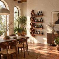 Wine rack with a tall wavy backbone and four notched shelf arms in a bright dining room with arched windows and plants