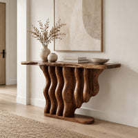 Console table with a base of wavy wood columns on an oval foot in a Scandinavian entryway with white walls
