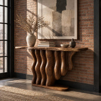 Console table with a base of wavy wood columns on an oval foot in an industrial loft entryway with exposed brick