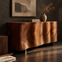 Corner detail of wavy edged sideboard with two front panels and bold wood grain beside wood, brass and linen samples