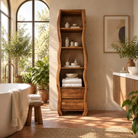 Tall narrow cabinet with wavy sides, four open shelves and two drawer fronts below in a bright bathroom with arched windows and plants
