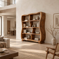 Wavy bookshelf with offset dividers and carved fan leaves on the side panel in a bright open plan living room