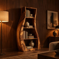 Tall bookshelf with wavy side panels and open shelves in an evening living room with walnut wall paneling