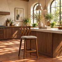 Bar stool with a wavy slatted back and a padded seat in a bright kitchen with arched windows and plants