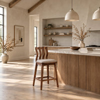 Bar stool with a wavy slatted back and a padded seat in a bright open plan kitchen