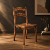 Wooden chair with two wavy back slats and tapered legs in a dark studio against a charcoal plaster wall