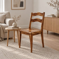 Wooden chair with two wavy back slats and tapered legs in a Scandinavian living room with white walls