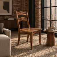 Wooden chair with two wavy back slats and tapered legs in an industrial loft living room with exposed brick