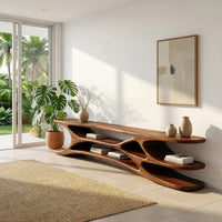 Low TV console with carved web supports between shelves in a sunlit room with large windows and plants
