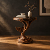 Side table with a carved whale tail on a spiral stem and coiled base in a dark studio against a charcoal plaster wall