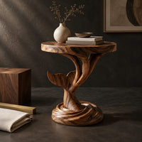 Corner detail of side table with a carved whale tail on a spiral stem and coiled base beside wood, brass and linen samples