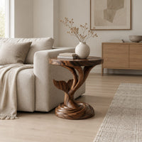 Side table with a carved whale tail on a spiral stem and coiled base in a Scandinavian living room with white walls