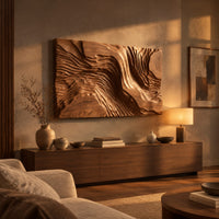 Wide wood wall art carved with flowing ridges like a contour map above a low console in an evening living room