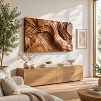 Wide wood wall art carved with flowing ridges like a contour map in a bright sunroom with green plants