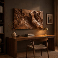 Wide wood wall art carved with flowing ridges like a contour map above a desk in a dark study corner