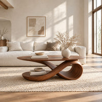 Oval top coffee table on a swooping ribbon pedestal with an oval base disc in a bright open plan living room