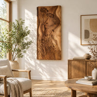 Tall wooden wall art panel with carved wildflowers and a wavy edge in a bright sunroom with green plants