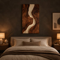 Tall wood wall art panel with a winding cream channel through dark swirling grain above a bed in a dusk lit bedroom