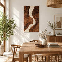 Tall wood wall art panel with a winding cream channel through dark swirling grain in a bright sunroom with green plants