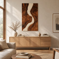 Tall wood wall art panel with a winding cream channel through dark swirling grain above a light oak sideboard in daylight