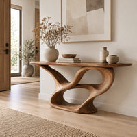 Console table with a winding ribbon base and a long tapered top in a Scandinavian entryway with white walls