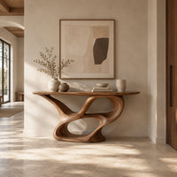 Console table with a winding ribbon base and a long tapered top in a bright open plan entryway