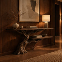 Console table with a leaning tree root base and one lower shelf in an evening entryway with walnut wall paneling