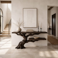 Console table with a leaning tree root base and one lower shelf in a bright open plan entryway