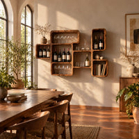 Wine rack made of linked open boxes in a staggered layout in a bright dining room with arched windows and plants