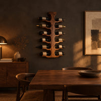 Wine rack with a central trunk and six pairs of branching wooden arms in a dark dining room at golden hour