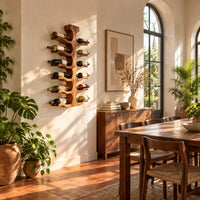 Wine rack with a central trunk and six pairs of branching wooden arms in a bright dining room with arched windows and plants