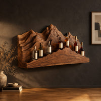 Wine rack with layered carved mountain peaks and a ridge shaped ledge in a dark studio against a charcoal plaster wall