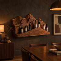 Wine rack with layered carved mountain peaks and a ridge shaped ledge in a dark dining room at golden hour