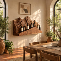 Wine rack with layered carved mountain peaks and a ridge shaped ledge in a bright dining room with arched windows and plants