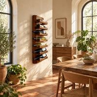 Tall wine rack with stacked angled cradle arms on a slab backboard in a bright dining room with arched windows and plants