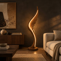 Wing shaped wooden floor lamp with a glowing edge line in a dark living room at golden hour
