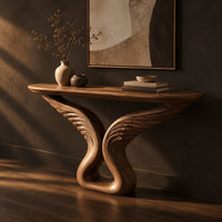 Console table with carved feather wings rising from a looped base, three-quarter view showing the grain