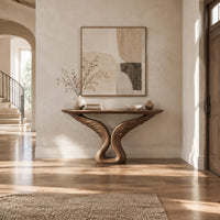 Console table with carved feather wings rising from a looped base in a bright open plan entryway