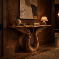 Console table with feather carved wings rising from an open teardrop base in an evening entryway with walnut wall paneling