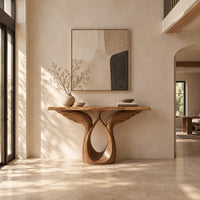Console table with feather carved wings rising from an open teardrop base in a bright open plan entryway