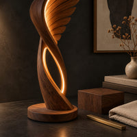Corner detail of winged floor lamp with layered feathers and a glowing oval loop beside wood, brass and linen samples