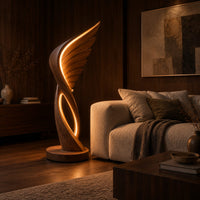Winged floor lamp with layered feathers and a glowing oval loop in an evening living room with walnut wall paneling
