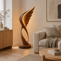 Winged floor lamp with layered feathers and a glowing oval loop in a Scandinavian living room with white walls